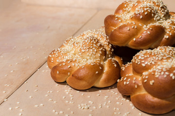 Buns with sesame seeds on a wooden background