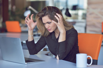 Frustrated angry woman screaming on her laptop.