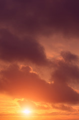 Naklejka premium Stormy clouds against the backdrop of the setting sun.