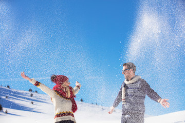 Carefree happy young couple having fun together in snow.
