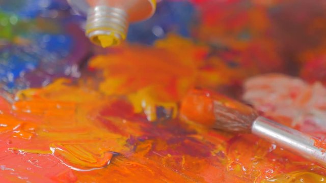 Closeup of Vibrant multi colored oil paints on a wooden palette