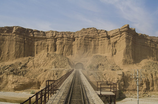 A Railway Line passing over a bridge and enetering into a tunnel