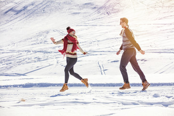 Carefree happy young couple having fun together in snow.