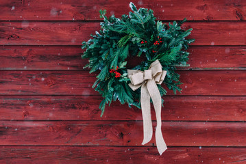 christmas wreath on a red barn wall