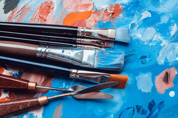 Artistic brushes on painted canvas