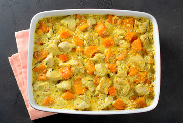 Chicken baked with pumpkin and cream sauce in a baking form on a