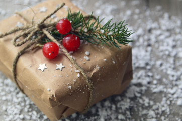 Gift box with fir tree,red berries and snowflakes on old wooden table.Christmas decoration.Winter holidays,Merry Christmas,Happy New Year concept.Selective focus.
