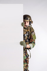 soldier with rifle  holding white panel with space for text on white background.