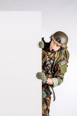 soldier with rifle  holding white panel with space for text on white background.
