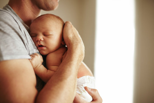 Tender moment between a father and newborn baby boy