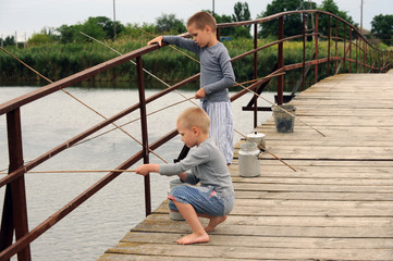 Three brothers came to the bridge in the village across the river to fish but instead ran along the bridge from the excess of feelings with a tourist aluminum kettle and small fish cans