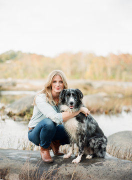 Woman in denim posing for a picture with her pet dog