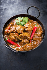 Traditional Indian curry lamb masala as close-up in a Korai