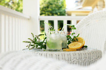 Homemade lemonade on white wicker furniture on the porch on a hot day