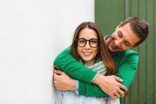 Young Man Embracing His Girlfriend On White Background.