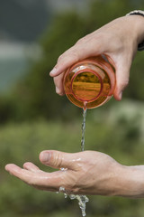 Hiker pours water from a water bottle on his hands