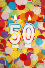 Celebration candle number 50 on a confetti background