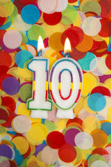Celebration candle number 10 on a confetti background