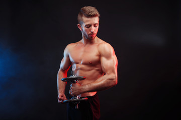 Fototapeta na wymiar Power, strength, excellent body, bodybuilding, sports concept. Young handsome muscular fit man with perfect body exercising with a dumbbell