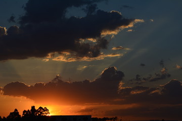 Por do sol avermelhado com raios