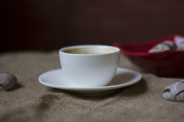 hot cup of coffee with couple of heart shaped chocolate cookies.