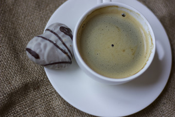 hot cup of coffee with couple of heart shaped chocolate cookies.