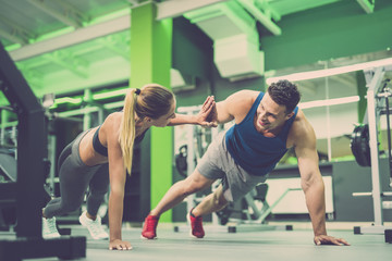 Fototapeta na wymiar The man and woman doing push up exercise and gesture in the gym