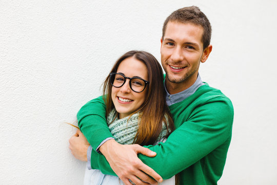 Young Man Embracing His Girlfriend On White Background.