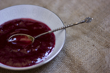 A perfect breakfast combo of jam, pancakes, and a hot cup of coffee.