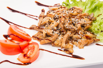 Pork with mushrooms in sauce, tomatoes in white plate, isolate