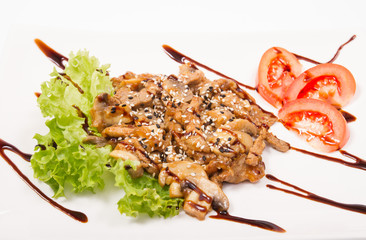 Pork with mushrooms in sauce, tomatoes in white plate, isolate