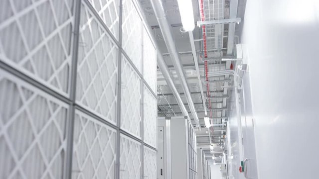 Empty interior of large modern data centre with pipelines overhead.