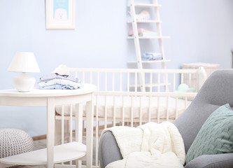 Baby bedroom design with white crib and armchair
