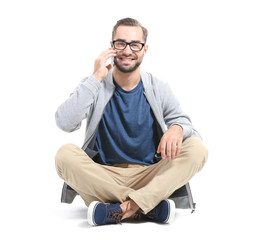 Attractive young man with smartphone on white background
