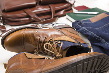 Men's casual outfits with leather accessories on white rustic wooden background, lifestyle...