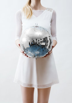 woman in white holding a shiny disco ball