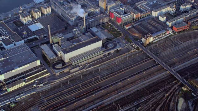  Aerial of railway tracks & industrial building with smoking chimney in Paris