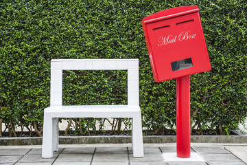 White tile stone chair with red mail box on cement blocks floor in the park, concept of relaxing