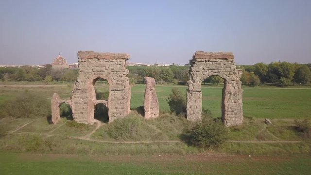 Video from above. Aerial view of the ancient Roman Aqueduct. Old ruins surrounded by a green public Park (Parco degli Acquedotti) Rome, Italy.	