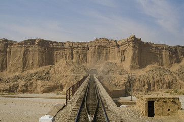A Railway Line passing over a bridge and enetering into a tunnel