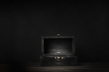 Old Dark Wooden Treasure Chest with Opened Lid on Black Background