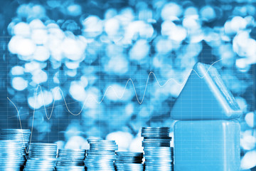 Double exposure of Model house wood form with step of coins stack on table with financial graph chart, real estate investment and saving banking money concept.