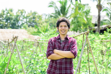 Asian young farmer standing in vegetables garden,organic farm