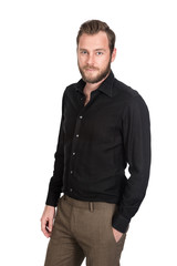 Fototapeta premium Handsome man wearing a black shirt and brown pants, hand in pocket standing against a white background looking at camera.