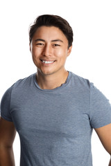 Handsome smiling man in his 20s, standing against a white background wearing a blue tshirt.