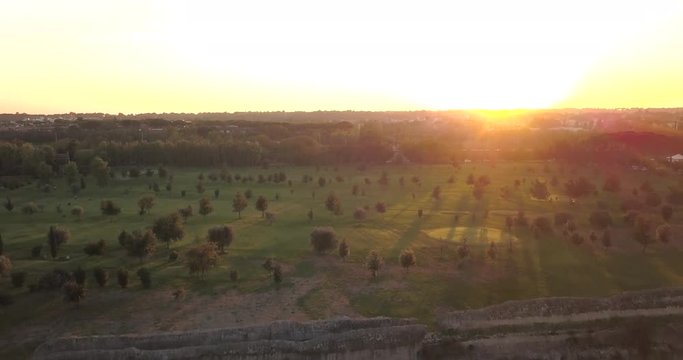 Video from above. Aerial view of the ancient Roman Aqueduct at sunset. Old ruins surrounded by a green public Park (Parco degli Acquedotti) Rome, Italy.