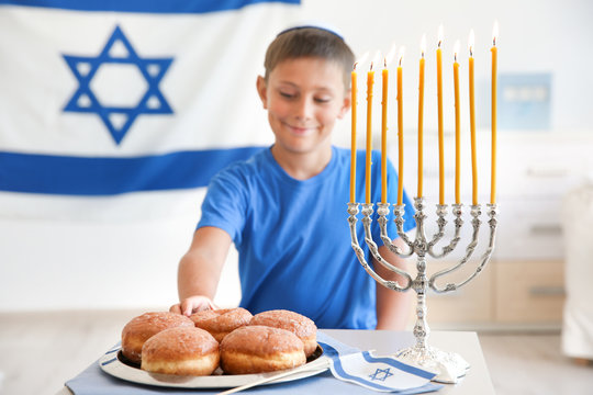 Jewish boy with traditional sufganiyah at home