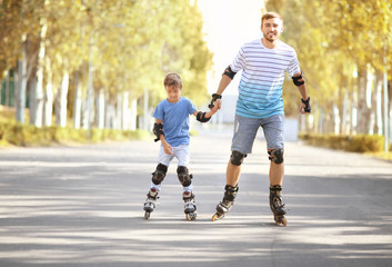 Father with son rollerskating in park