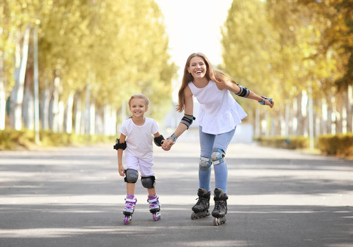 Mother with daughter rollerskating in park