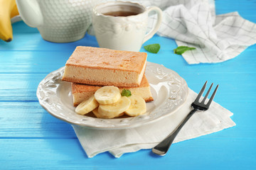 Plate with tasty banana cakes on wooden table